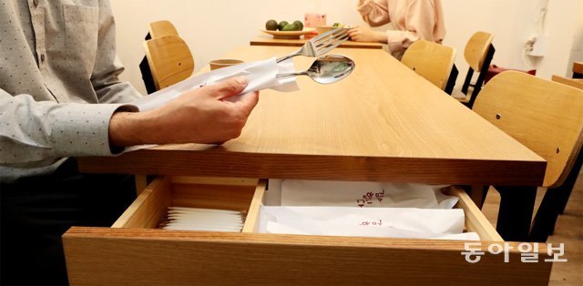 서울의 한 식당에서 손님이 종이로 개별 포장된 수저와 포크를 들고 있다. 포장 덕에 이물질이 묻는 걸 막을 수 있다. 김재명 기자 base@donga.com
