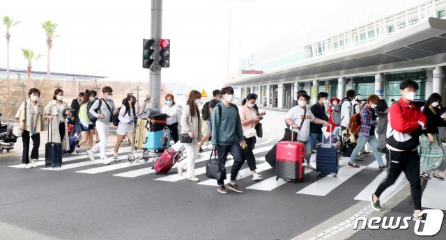 제주국제공항에서 마스크를 쓴 관광객들이 횡단보도를 건너고 있다.© 뉴스1