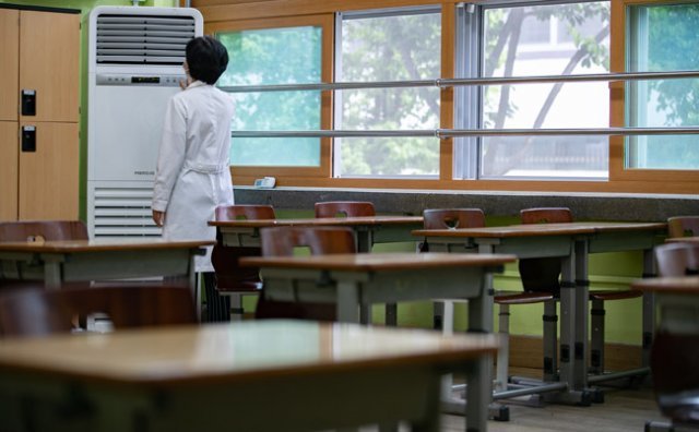 등교개학을 앞둔 5월 7일 서울 성동구 무학여자고등학교에서 한 교사가 에어컨 가동 점검을 하고 있다. [뉴스1]