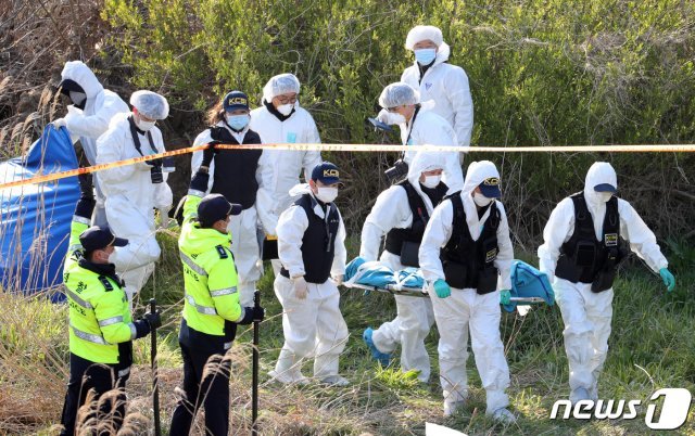 23일 전북 진안군 한 천변에서 지난달 14일 실종된 여성으로 추정되는 시신을 과학수사 관계자들이 옮기고 있다. 2020.4.23/뉴스1 © News1