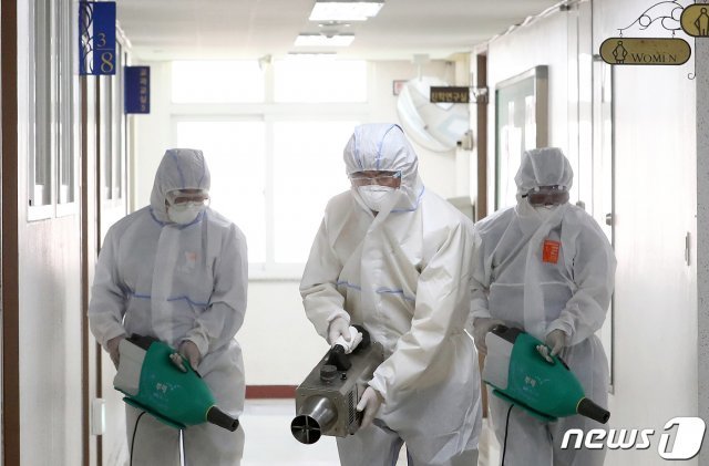 지난 11일 서울영동일고등학교 고3 교실 복도에서  방역 관계자들이 방역을 하고 있다. /뉴스1 © News1