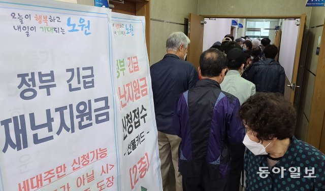 정부의 긴급재난지원금 방문 접수 첫날인 18일 서울 노원구 한 주민센터에 신청자들이 차례를 기다리고 있다.