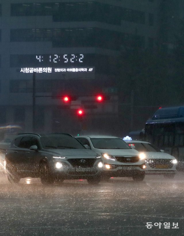 서울 지역에 폭우가 내린 18일 오후 4시 경 대낮인데도 불구하고 시청 광장 앞 도로에 자동차들이 헤드라이트를 켜고 주행하고 있다. 송은석 기자 silverstone@donga.com