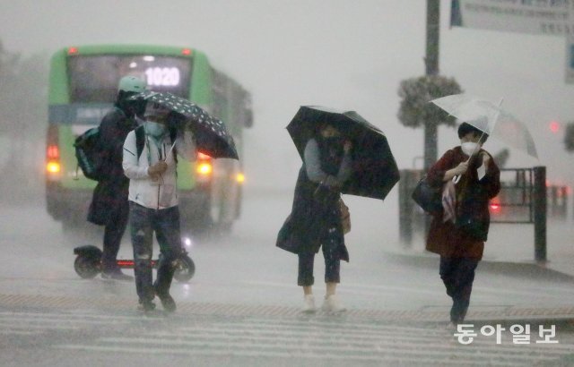 18일 오후 4시경 서울 세종로 네거리에서 하늘이 어두워지며 갑자기 폭우가 쏟아지자 시민들이 발걸음을 재촉하며 빗속을 걷고있다. 전영한 기자 scoopjyh@donga.com