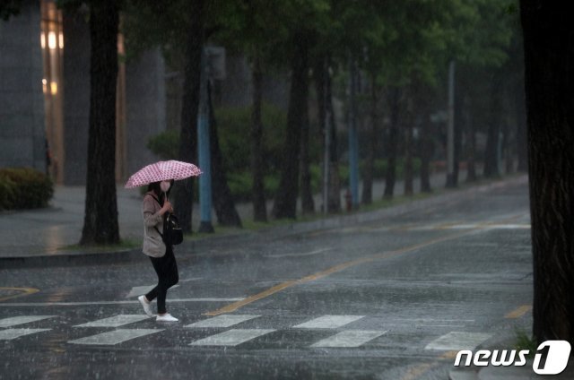 비가 내리는 18일 오후 서울 종로구 광화문역 앞에서 우산을 쓴 시민들이 걸음을 재촉하고 있다. 2020.5.18 © News1