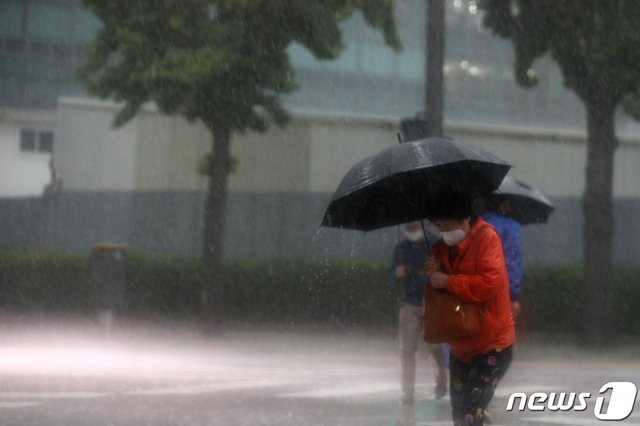 비가 내리는 18일 오후 서울 종로구 정부서울청사 앞에서 우산을 쓴 시민들이 걸음을 재촉하고 있다. 2020.5.18/뉴스1 © News1