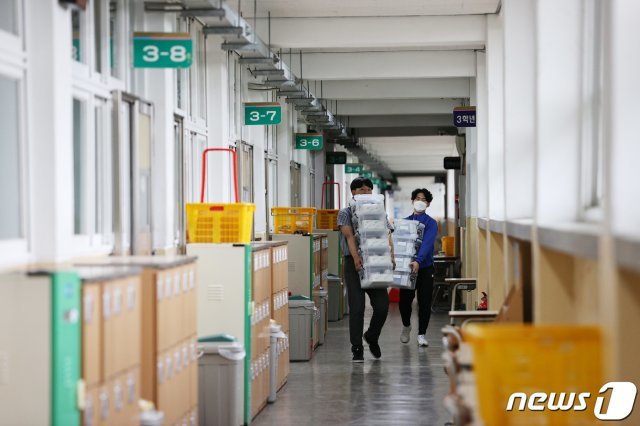 19일 서울 영등포구 여의도고등학교에서 교직원들이 학생들의 위한 방역용품을 옮기고 있다. /뉴스1 © News1