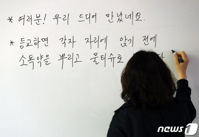 고등학교 3학년 학생들의 등교수업을 하루 앞둔 19일 오후 서울 종로구 경복고등학교에서 한 교사가 학생들을 위한 안내문을 작성하고 있다. 2020.5.19 © News1