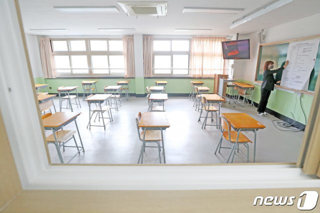 고등학교 3학년 학생들이 등교 개학한 20일 오후 경기도 안성시 안법고등학교에서 교사가 학생들이 등교하면 치를 전국연합학력평가 시간표를 부착하고 있다. 앞서 안성 소재 고등학교들은 신종 코로나바이러스 감염증(코로나19) 지역 확진자 발생으로 등교 중지가 내려졌으며 21일부터 정상 등교할 예정이다. 2020.5.20/뉴스1 © News1