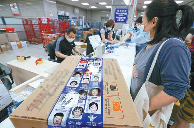 서울 종로구 광화문우체국에서 한 시민이 장기 실종아동의 사진이 인쇄된 ‘호프 테이프’로 포장한 택배를 접수시키고 있다. 뉴시스