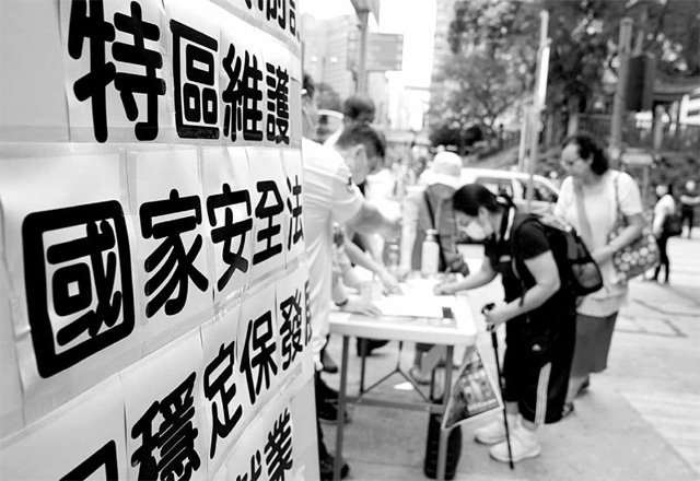 시위대 200명 체포 속 보안법 지지 서명 운동 중국의 ‘홍콩 국가보안법’ 제정 지지자들이 23일 홍콩 도심에서 ‘국가보안법이 홍콩 안정을 보장한다’는 문구를 내걸고 법안 찬성 서명 운동을 벌이고 있다. 24일 법안 반대 시위에 나선 반중파 홍콩 시민 중 약 200명이 경찰에 체포돼 홍콩의 긴장감이 높아지고 있다. 홍콩=신화 뉴시스