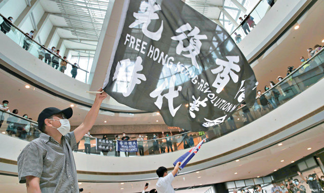 중국의 홍콩 국가보안법 제정에 반대하는 홍콩 시위대가 29일 한 쇼핑몰에서 ‘광복홍콩 시대혁명’이라는 구호가 쓰인 깃발을 흔들고 있다. 홍콩에서는 중국 정부가 보안법을 이용해 2014년 우산혁명을 주도한 조슈아 웡 등을 체포하고 공안정국을 조성할 것으로 우려하고 있다. 홍콩=AP 뉴시스