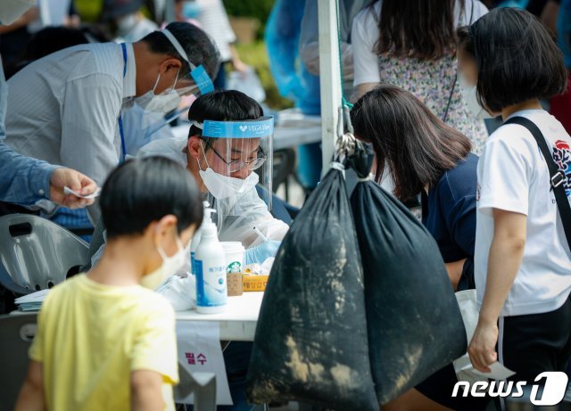 지난달 30일 서울 영등포구 자매근린공원 현장선별진료소에서 의료진이 문진을 하고 있다. /뉴스1 © News1