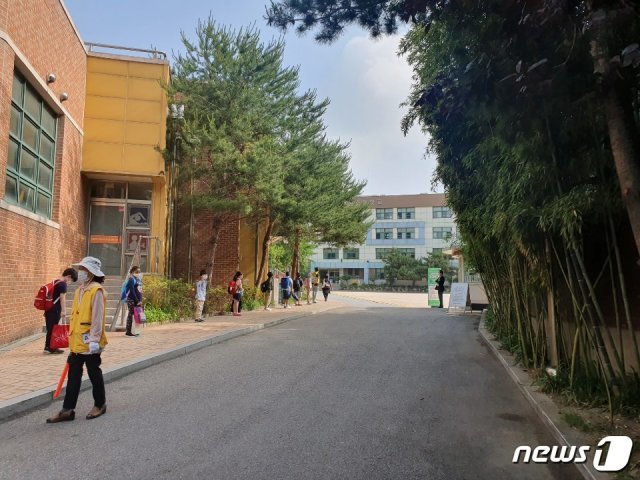 3일 오전 서울 용산구 서울이태원초등학교 정문에서 아이들이 거리두기를 하며 등교 시간을 기다리고 있다 © 뉴스1