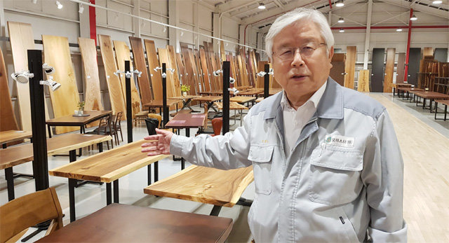 이경호 영림목재 회장이 2일 인천 남동산업단지 내 본사 원목 우드슬랩 전시장에서 수백 년 된 원목 테이블의 원산지와 나무의 특징을 설명하고 있다.