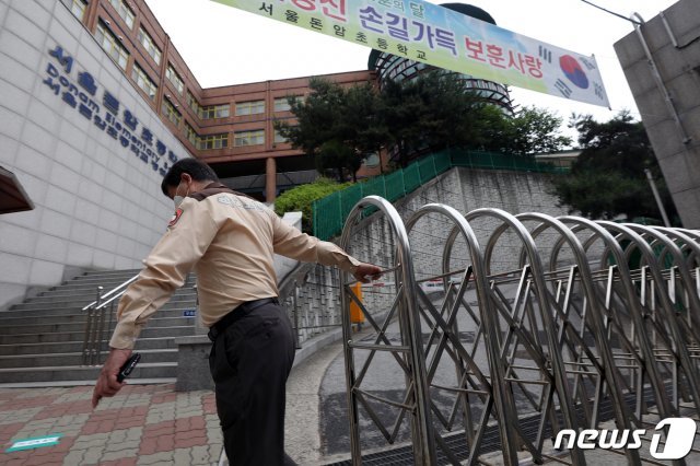 지난 2일 서울 성북구 돈암초등학교에서 학교보안관이 교문을 닫고 있다. © News1