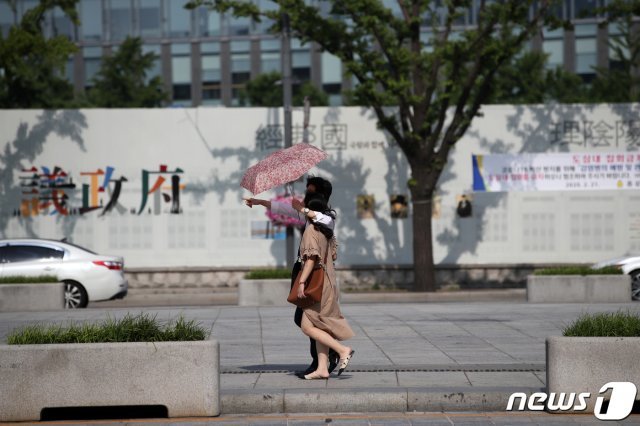 전국의 낮기온이 30도 안팎까지 오르는 7일 오후 서울 세종대로 일대에서 시민들이 양산을 쓰고 발걸음을 옮기고 있다. 2020.6.7/뉴스1 © News1