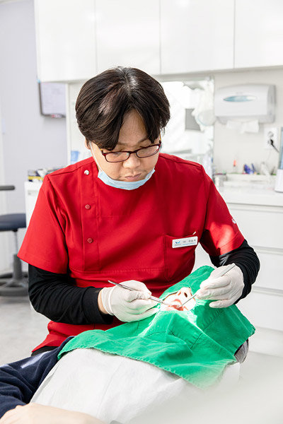 치근피개술은 치아의 시린 증상을 개선하고 들쑥날쑥한 잇몸 라인을 고르게 만들어 만족도가 높은 치주질환 치료다. 환자를 치료하고 있는 우승욱 원장.