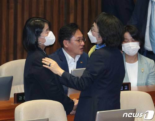 윤미향 더불어민주당 의원과 김진애 열린민주당 원내대표가 지난 5일 오전 서울 여의도 국회에서 열린 제21대 국회 첫 본회의에서 대화하고 있다. 김 원내대표는 이때 윤 의원 얼굴이 정면에서 노출되는 것을 막아주려 일부러 몸을 틀었다고 했다. ⓒ News1