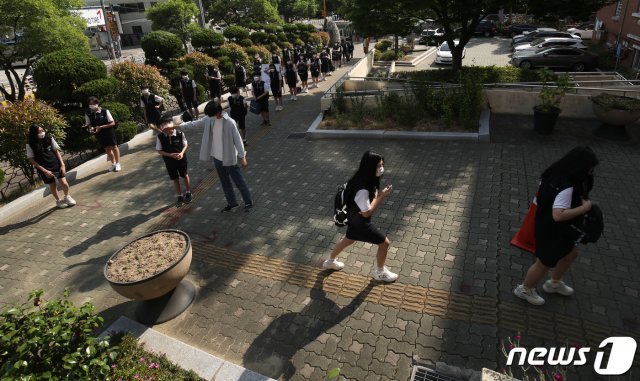 (울산=뉴스1) 4차 등교 수업이 실시된 8일 오전 울산 남구 문수중학교에서 1학년 학생들이 교실로 들어가기 전 체온측정을 받기 위해 거기를 두고 대기하고 있다. 2020.6.8/뉴스1