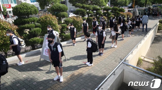 (울산=뉴스1) 4차 등교 수업이 실시된 8일 오전 울산 남구 문수중학교에서 1학년 학생들이 교실로 들어가기 전 체온측정을 받기 위해 거리를 두고 대기하고 있다. 2020.6.8/뉴스1