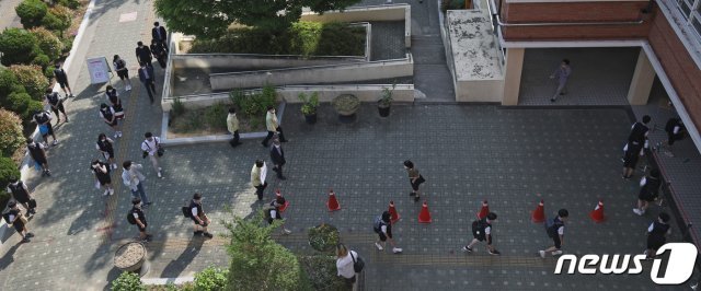 4차 등교 수업이 실시된 8일 오전 울산 남구 문수중학교에서 1학년 학생들이 교실로 들어가기 전 체온측정과 손 소독을 하기 위해 거기를 두고 대기하고 있다. 2020.6.8/뉴스1 © News1