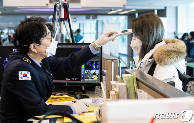 인천국제공항 제1여객터미널 입국장에서 검역 관계자들이 중국 톈진에서 입국한 관광객을 대상으로 발열 검사를 하고 있다 © News1