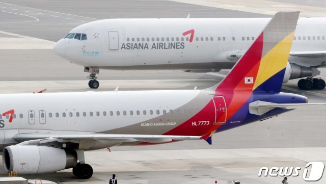 서울 강서구 김포공항 계류장에서 관계자들이 아시아나항공 여객기에 화물을 싣고 있다. 뉴스1 © News1