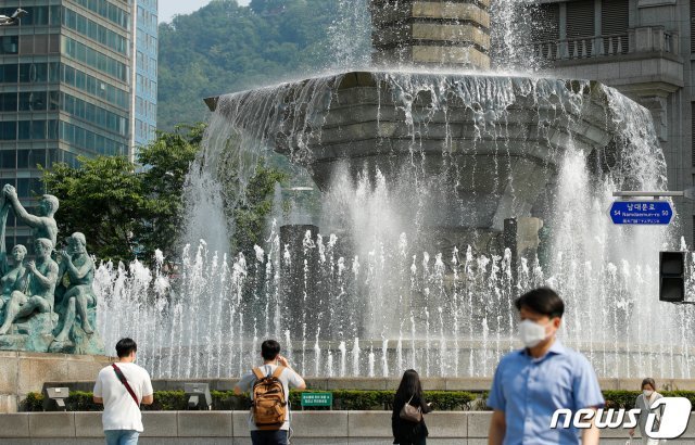 서울에 첫 폭염주의보가 발령된 8일 오후 서울 중구 한국은행 분수대 앞을 시민들이 걸어가고 있다. 2020.6.8/뉴스1 © News1