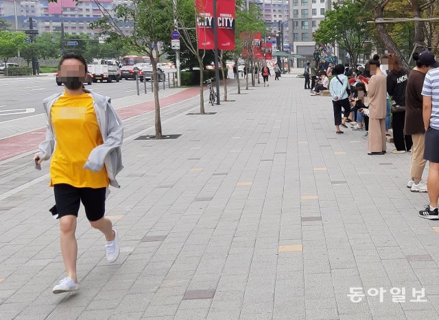 한 시민이 마스크 구입 줄을 서기위해 달려가고 있다.