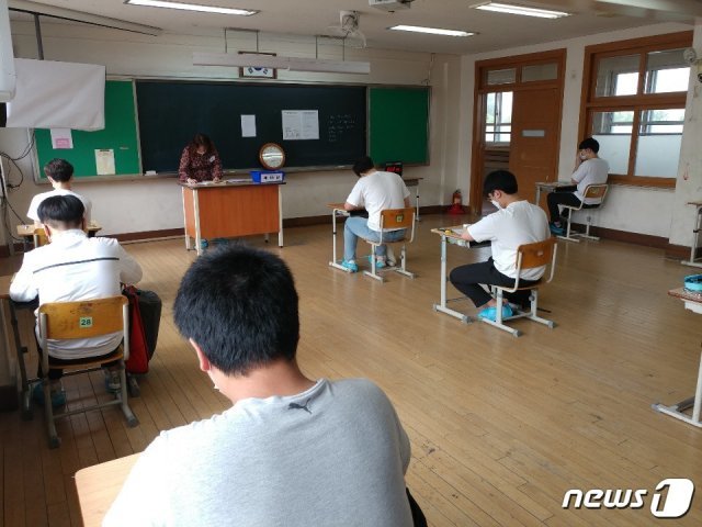 대전교육청 지방공무원 필기시험장인 대전 삼천중학교 앞에서 수험생들이 시험 준비에 몰두하고 있다.  수험생 간 거리두기를 위해 교실당 10명 내외로 배치했다. ⓒ 뉴스1