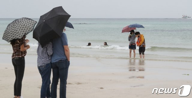 17일 오후 제주시 한림읍 협재해수욕장에서 우산을 쓴 관광객들.2020.6.17/뉴스1 © News1