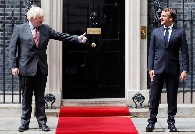 英-佛 정상 ‘거리두기’ 대면 보리스 존슨 영국 총리(왼쪽)가 18일(현지 시간) 런던의 총리관저 앞에서 에마뉘엘 마크롱 프랑스 대통령을 바라보며 엄지를 세워 보이고 있다. 이날 두 사람은 신종 코로나바이러스 감염증 예방
차원에서 거리를 두고 사진을 촬영했다. 런던=AP 뉴시스