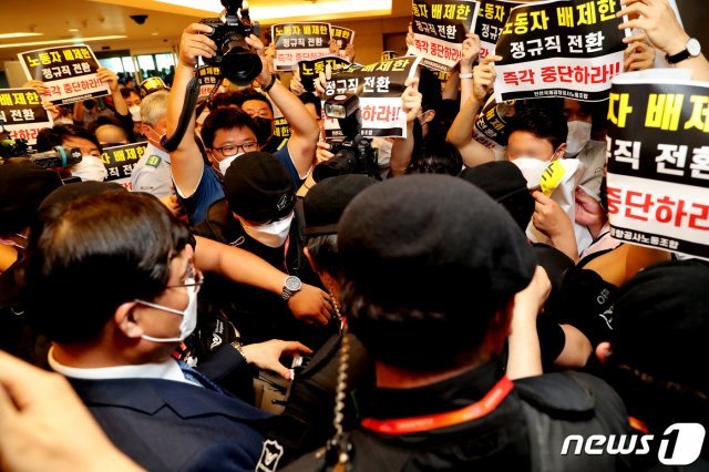 구본환 인천국제공항공사 사장이 22일 오후 인천공항1터미널에서 열린 기자회견에서 정규직 전환에 대한 입장을 밝히고 퇴장하자 ‘노동자 배제한 정규직 전환 즉각 중단하라’는 내용의 피켓을 든 노동조합원들이 항의를 하고 있다. 인천공항공사는 22일 인천공항 보안요원 1900여명을 정규직화 한다고 밝혔다. 2020.6.22/뉴스1 ⓒ News1