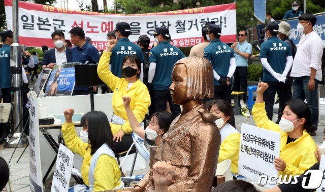 반아베반일청년공동행동 회원들이 23일 서울 종로구 옛 일본대사관 건너편에서 소녀상과 몸에 밧줄을 묶고 구호를 외치고 있다. 2020.6.23/뉴스1 © News1