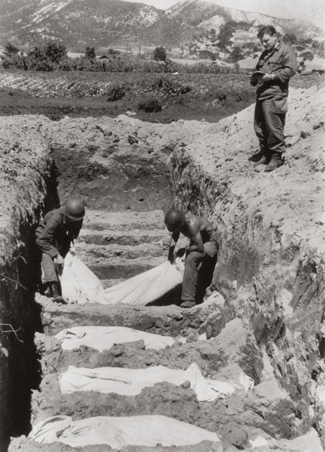 경북 김천 부근의 매장지에 군목이 지켜보는 가운데 미군 전사자의 시신을 묻고 있다. 1950. 8. 9. Carl Mydans 눈빛출판사 제공