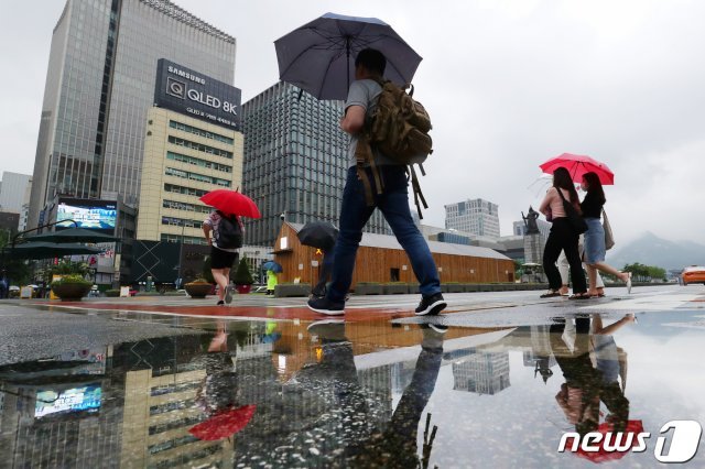 전국적으로 장맛비가 내린 24일 서울 종로구 광화문광장에서 우산을 쓴 시민들이 걸음을 재촉하고 있다. 2020.6.24 © News1