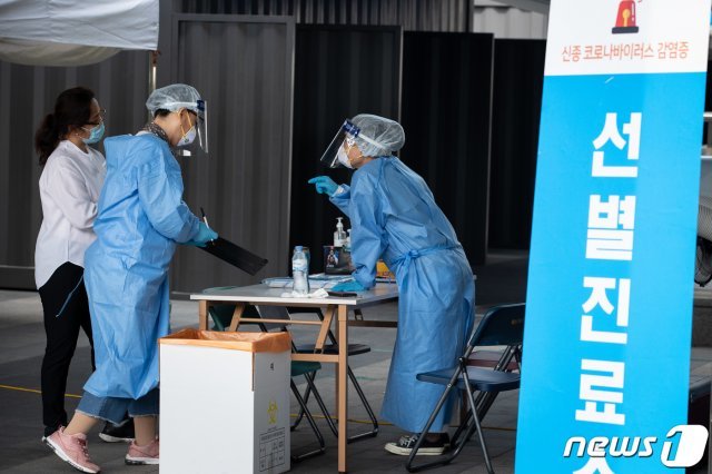 지난 23일 서울시내 한 신종 코로나바이러스 감염증(코로나19) 선별진료소에서 방역복을 착용한 관계자들이 업무를 보고 있다. 뉴스1 © News1