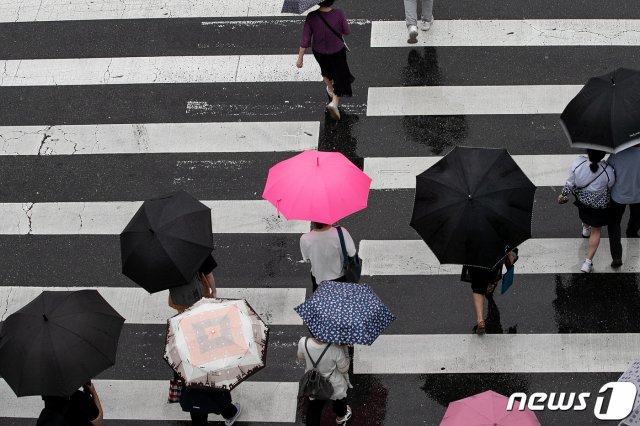 서울 광진구의 한 거리에서 시민들이 우산을 쓰고 발걸음을 옮기고 있다. 2020.6.24 © News1