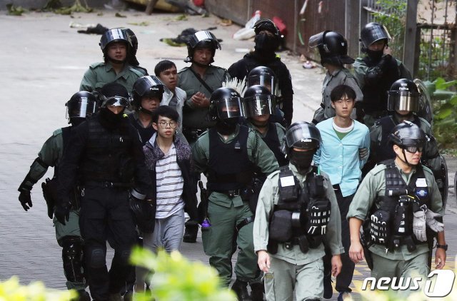 20일 오전 홍콩 이공대학교에서 시위 참여 학생들이 탈출에 실패한 후 경찰과 함께 나서고 있다. 2019.11.20/뉴스1 © News1