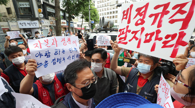 민노총 내부 반발에… 노사정 협약식 못간 위원장 검은색 마스크를 쓴 김명환 전국민주노동조합총연맹 위원장이 1일 서울 중구 민노총 사무실로 출근하던
도중 조합원들에게 둘러싸여 항의를 받고 있다. 김 위원장은 이날 국무총리공관에서 열릴 예정이던 코로나19 위기 극복을 위한 노사정 대표자 협약식에서 합의안에 서명할
예정이었으나 일부 조합원의 반대에 부딪혀 참석하지 못했다. 뉴시스