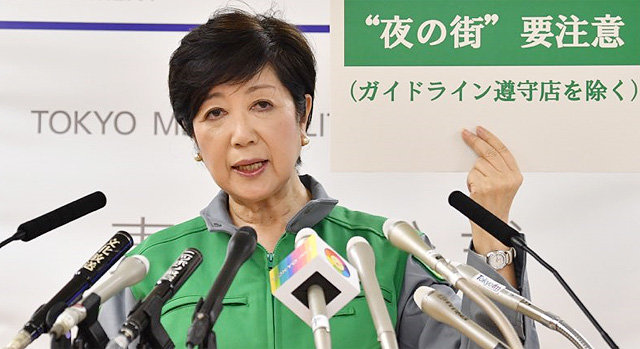 고이케 유리코 일본 도쿄도지사가 2일 기자회견에서 ‘밤거리 요주의’라고 적힌 피켓을 들고 있다. 아사히신문제공