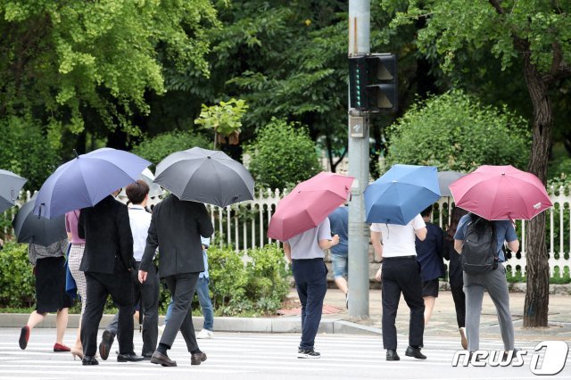 서울 시내의 한 거리에서 시민들이 우산을 쓰고 발걸음을 옮기고 있다.  2020.6.30/뉴스1 © News1