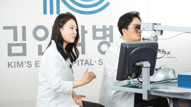 본보 이진한 의학전문기자(오른쪽)가 김안과병원 정종진 안과 교수의 도움을 받아 백내장 가상현실(VR) 시뮬레이터 기기로 백내장 수술을 간접체험하고 있다. 김안과병원 제공