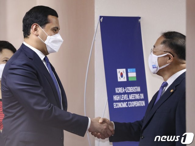 홍남기 경제부총리 겸 기획재정부 장관(오른쪽)과 사르도르 우무르자코프 우즈베키스탄 부총리 겸 투자대외무역부장관이 7일 오후 서울 종로구 정부서울청사에서 열린 ‘한-우즈벡 경제부총리 회의’를 앞두고 악수하고 있다. 2020.7.7/뉴스1 © News1