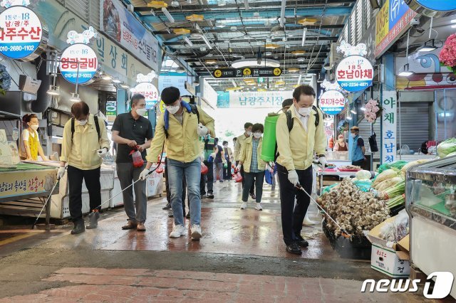 7일 광주 동구 남광주시장에서 임택 동구청장과 주민자치계 직원 등이 신종 코로나바이러스 감염증(코로나19) 지역 확산 예방을 위해 방역 소독하고 있다.(광주 동구 제공) 2020.7.7 /뉴스1 © News1