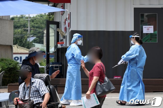 지난 6일 한 선별진료소에서 의료진들이 코로나19 검사를 받기 위해 찾아온 시민들을 돌보고 있다. /뉴스1 © News1