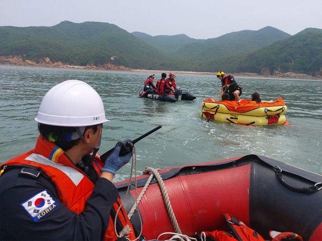 해경 구조대원들이 지난달 5일 인천 중구 무의도 하나개해수욕장 갯벌에서 조개를 캐다 밀물에 고립됐던 일가족 8명을 구조하고 있다. 해양경찰청 제공
