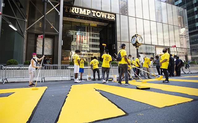 9일(현지 시간) 미국 뉴욕 맨해튼 5번가 트럼프타워 앞 도로에서 인종차별 반대 시위대가 노란색 페인트로 ‘흑인 생명도 소중하다(Black Lives Matter)’라는 문구를 칠하고 있다. 뉴욕=AP 뉴시스