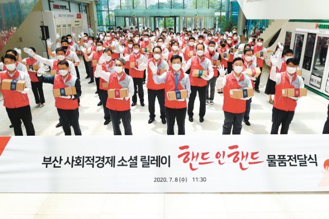 BNK부산은행은 8일 부산 사회적경제기업이 생산한 ‘핸드 인 핸드’ 물품을 구입해 본점 인근 저소득 가구에 전달하는 임직원 봉사활동을 펼쳤다. 빈대인 부산은행장(앞줄 오른쪽에서 세 번째)을 비롯한 임직원들이 행사 시작 전 파이팅을 외치고 있다. 부산은행 제공